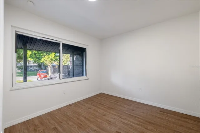 an empty room with wooden floor and a window
