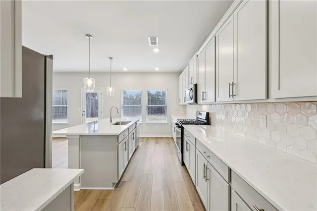 a kitchen with stainless steel appliances granite countertop a lot of counter space and wooden floors