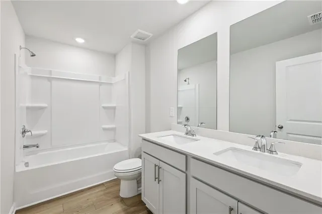 a bathroom with a granite countertop sink toilet tub and shower