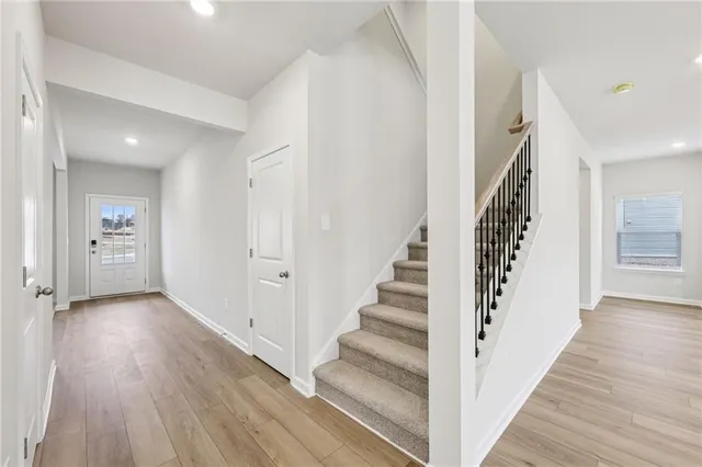 a view of a hallway with wooden floor and entryway