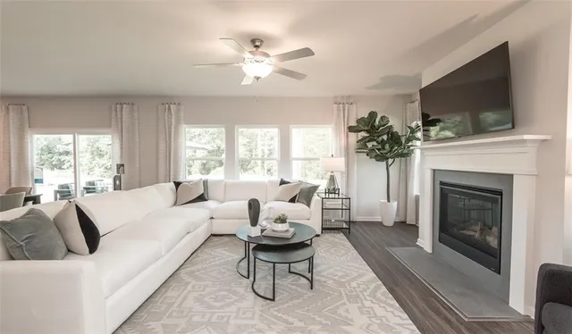 a living room with furniture kitchen view and a wooden floor