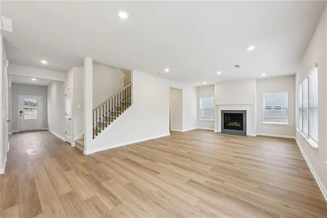 a view of empty room with wooden floor and fireplace