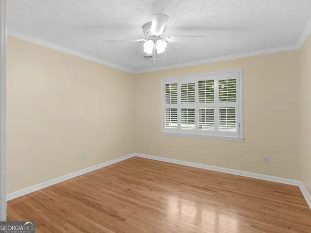 a view of a room with wooden floor and a ceiling fan