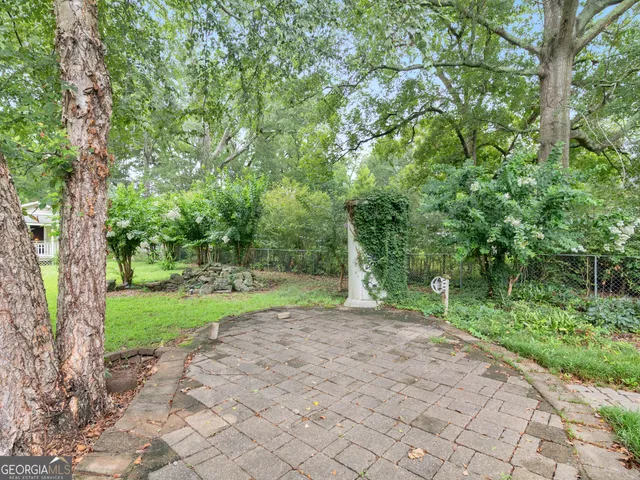 a view of a yard with plants and trees