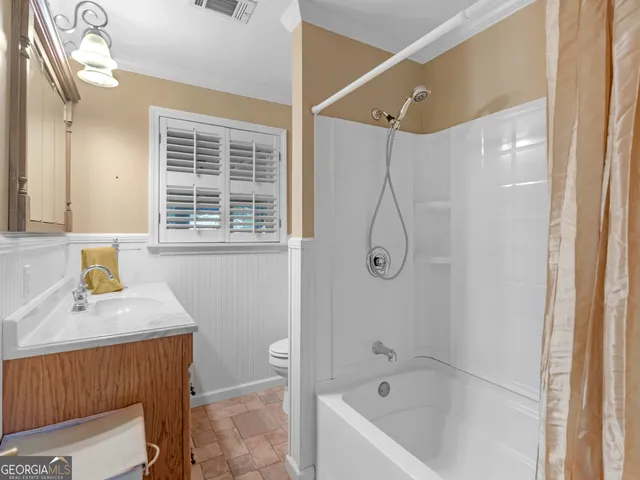 a bathroom with a granite countertop sink a toilet and shower