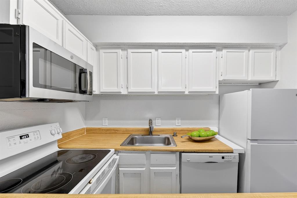 9825 Walnut Street, Unit 306 Dallas, TX 75243 - Photo 6 of 23 a kitchen with a sink a stove and cabinets