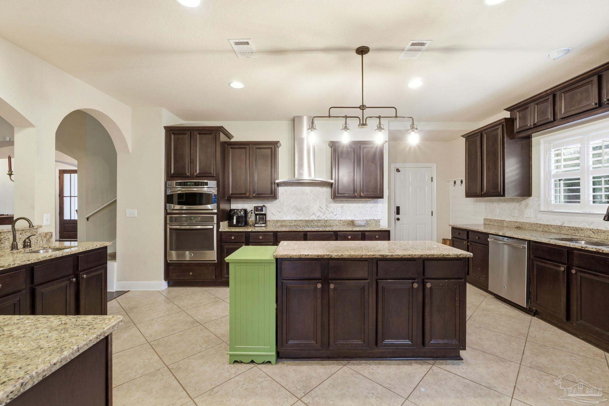 1207 Wings Way Cantonment, FL 32533 - Photo 13 of 39 a kitchen with kitchen island granite countertop a sink counter top space appliances and cabinets