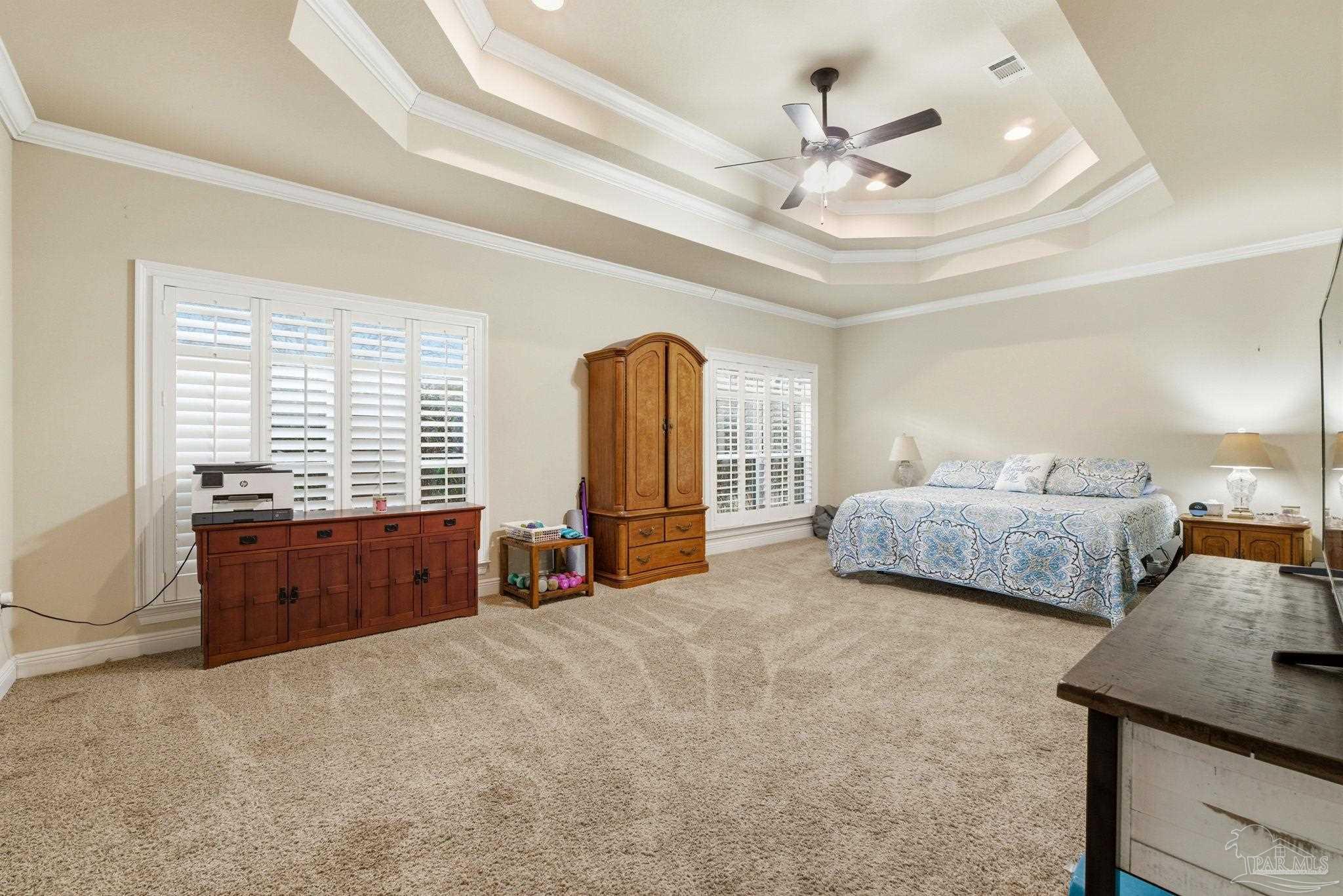 1207 Wings Way Cantonment, FL 32533 - Photo 18 of 39 a spacious bedroom with a bed a window and a chandelier