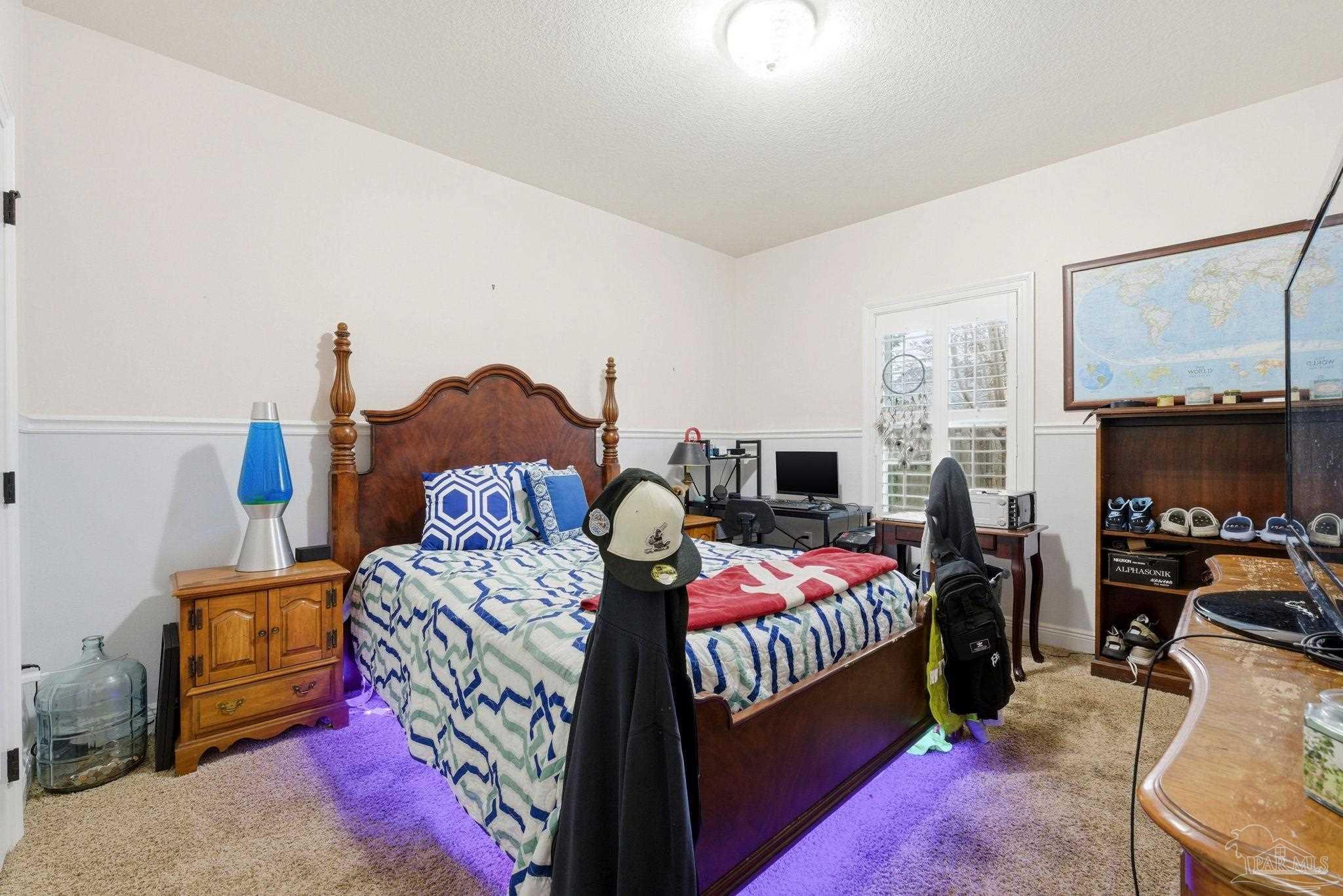 1207 Wings Way Cantonment, FL 32533 - Photo 22 of 39 a bedroom with a bed a couch and dresser