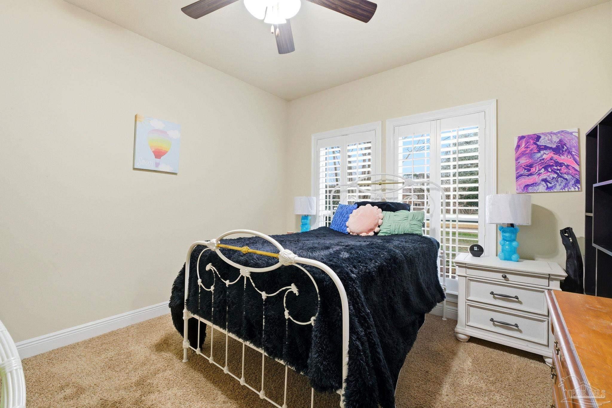 1207 Wings Way Cantonment, FL 32533 - Photo 26 of 39 a bedroom with a bed and a chandelier