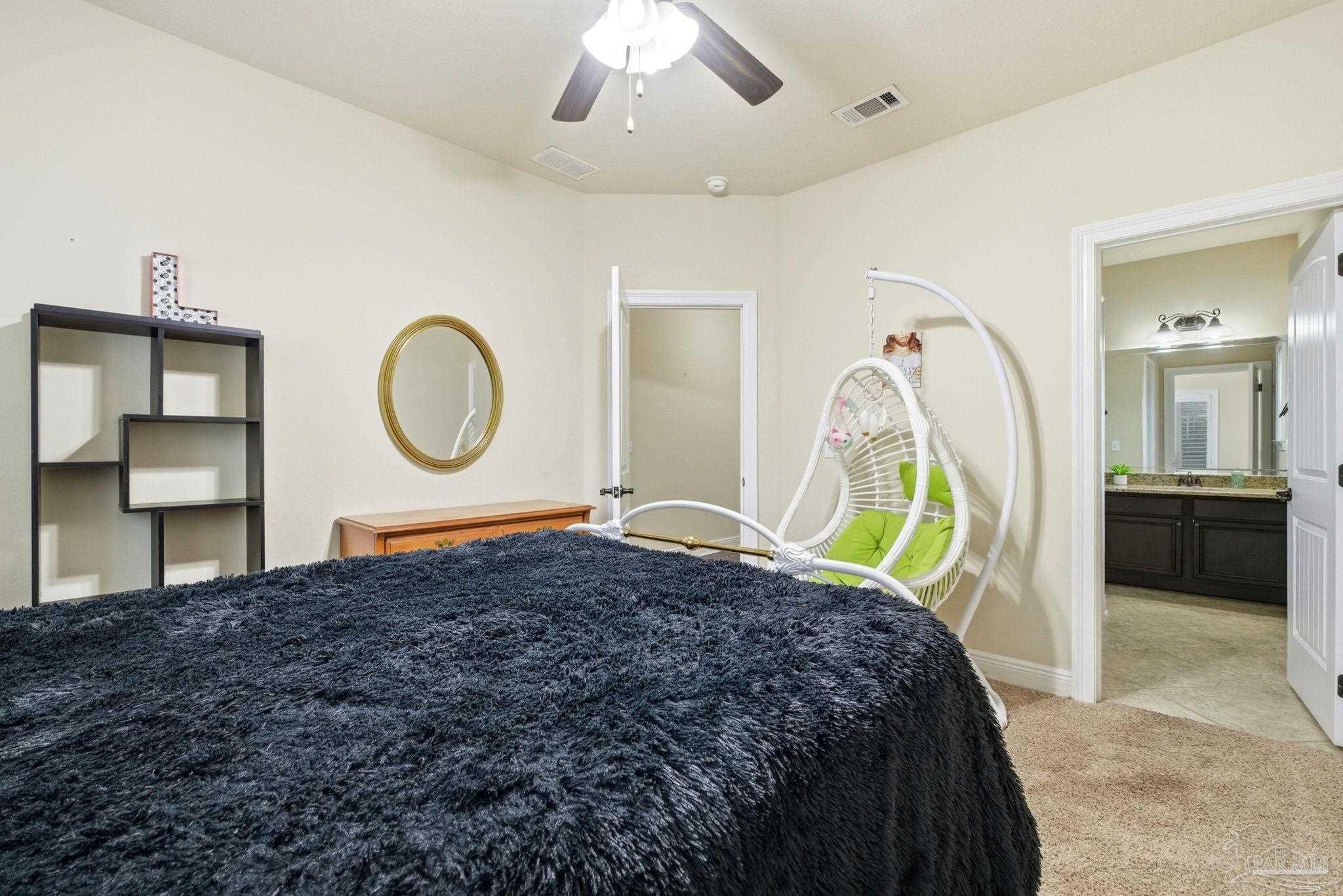 1207 Wings Way Cantonment, FL 32533 - Photo 27 of 39 a bed room with a bed mirror and a chandelier