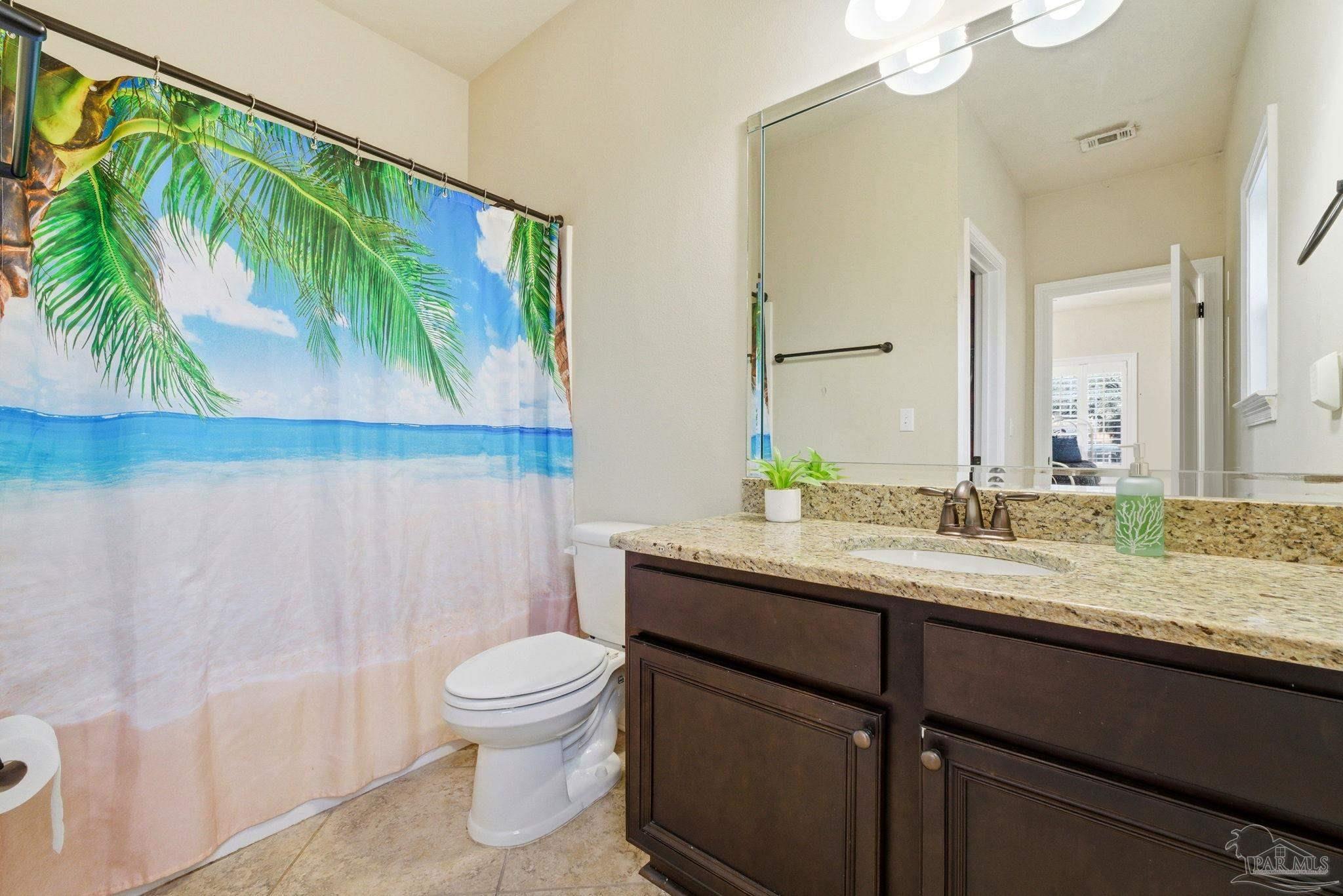 1207 Wings Way Cantonment, FL 32533 - Photo 28 of 39 a bathroom with a granite countertop sink a toilet and a mirror
