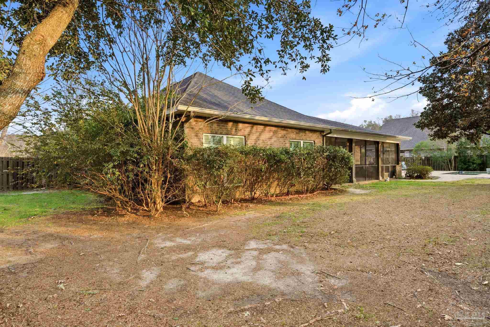 1207 Wings Way Cantonment, FL 32533 - Photo 35 of 39 a view of yellow house with a big yard and large trees