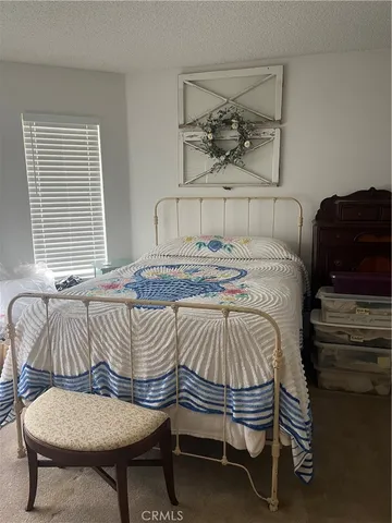 a bedroom with a bed a dresser and chair
