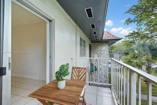 a balcony with wooden floor barbeque oven and potted plants