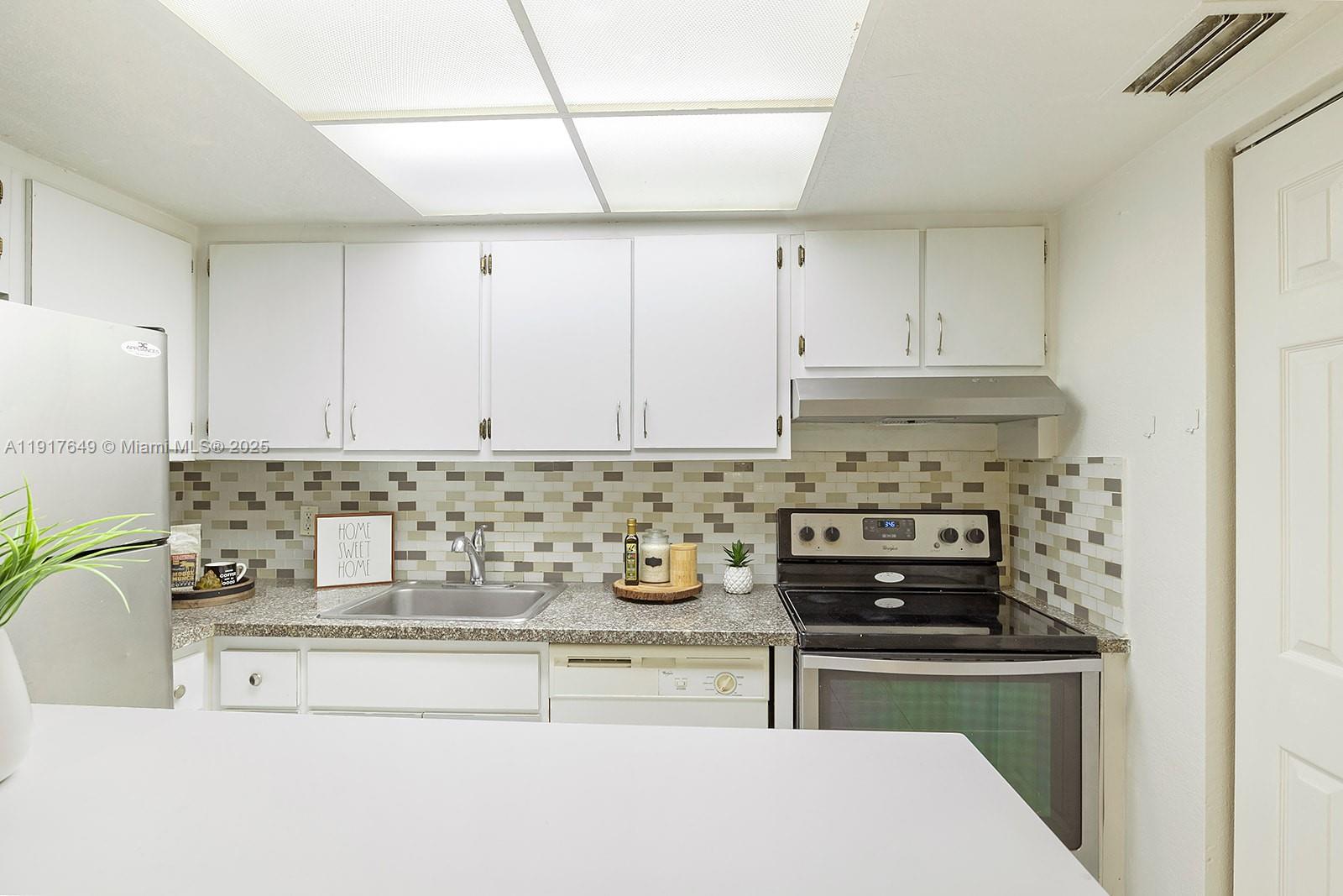 6530 Lake Patricia Drive, Unit E25 Miami Lakes, FL 33014 - Photo 3 of 16 a kitchen with a stove and a cabinets