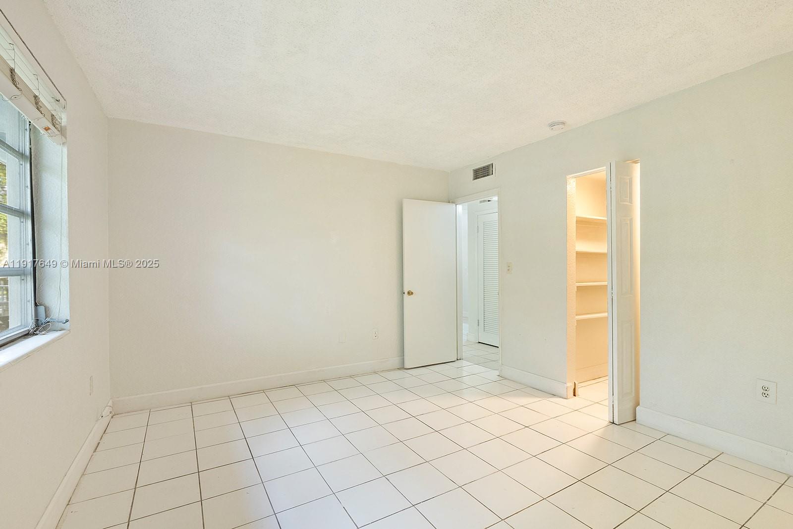 6530 Lake Patricia Drive, Unit E25 Miami Lakes, FL 33014 - Photo 9 of 16 a view of an empty room and window
