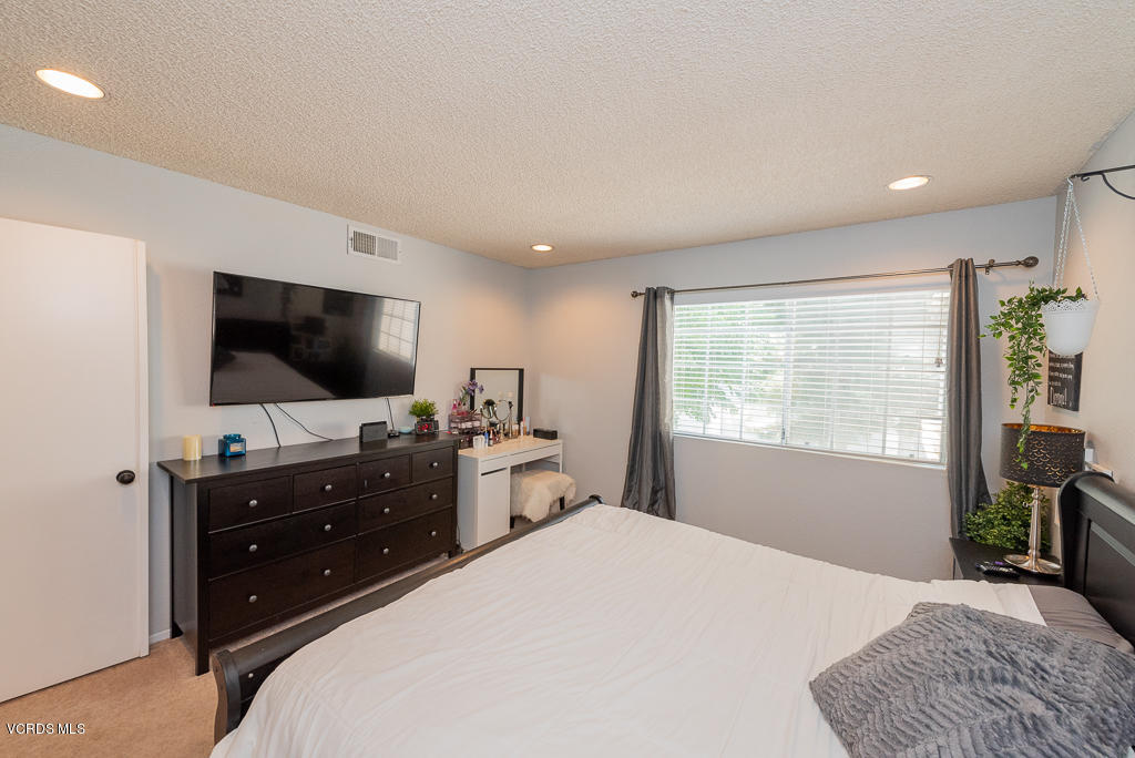 1135 Fitzgerald Road, Unit A Simi Valley, CA 93065 - Photo 27 of 49 a bedroom with a bed and a flat screen tv
