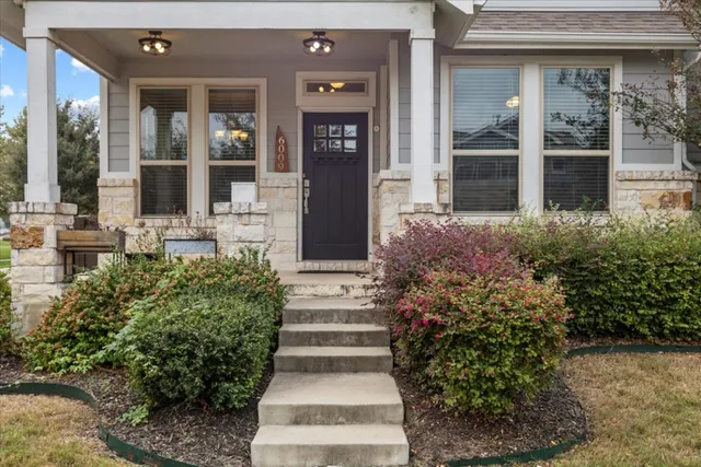 a front view of a house with plants