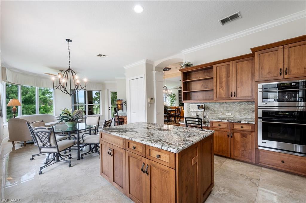 3019 Lancaster Drive, Unit 3 Naples, FL 34105 - Photo 13 of 35 a kitchen with stainless steel appliances granite countertop a stove top oven a sink dishwasher a dining table and chairs with wooden floor