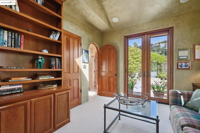 a living room with furniture a bookshelf and a window