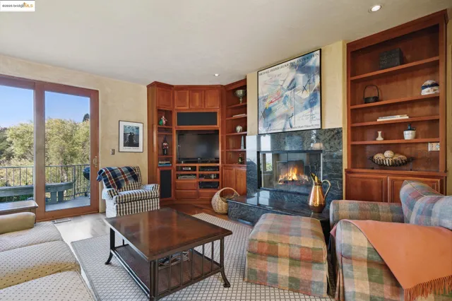 a living room with furniture a fireplace and a large window