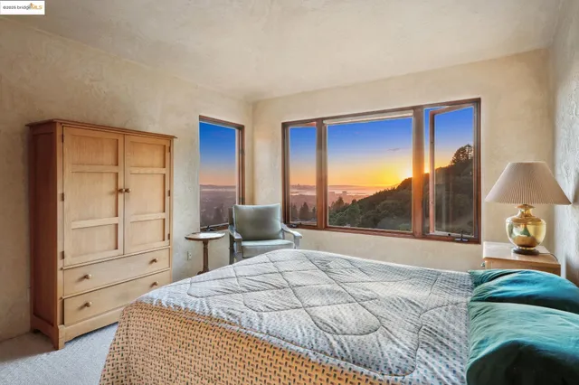a bed sitting in a bedroom next to a window