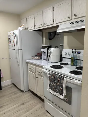 a white stove top oven sitting inside of a kitchen