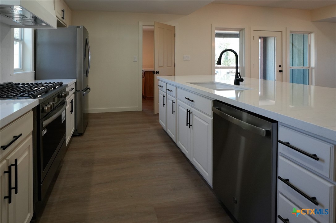 5688 Falke-Heinrich Road Schulenburg, TX 78956 - Photo 14 of 34 a kitchen with stainless steel appliances granite countertop a sink and a refrigerator