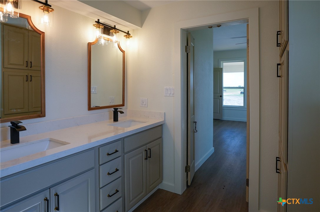 5688 Falke-Heinrich Road Schulenburg, TX 78956 - Photo 24 of 34 a en suite bathroom with a double vanity sink and mirror
