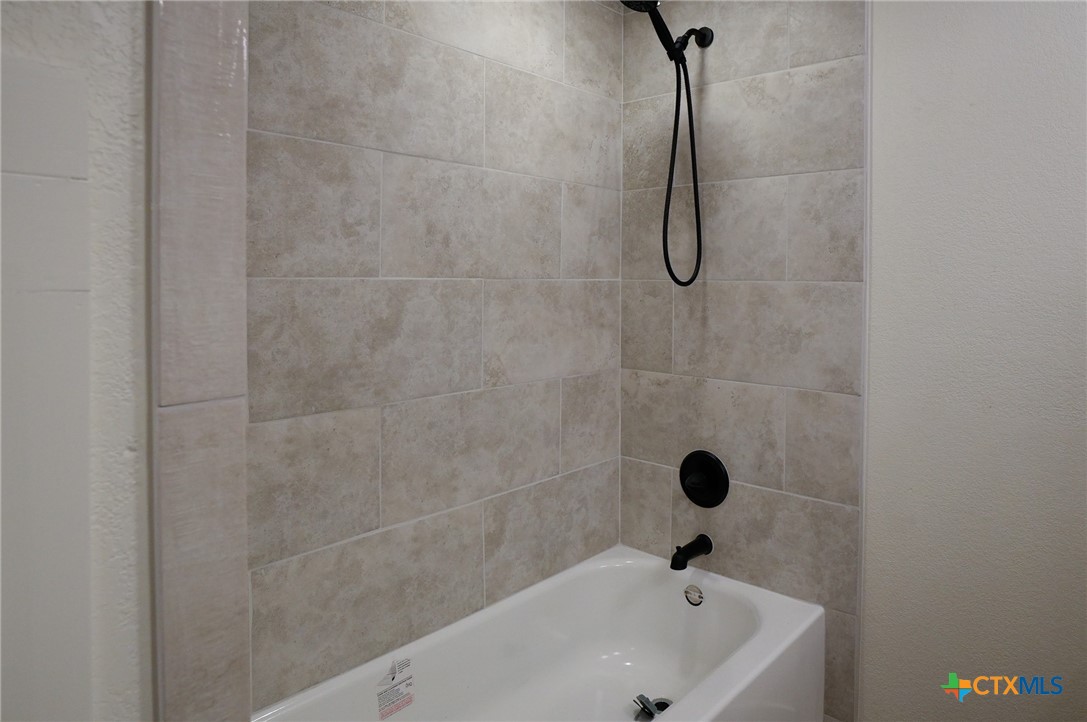 5688 Falke-Heinrich Road Schulenburg, TX 78956 - Photo 30 of 34 a bathroom with a bath tub with a shower