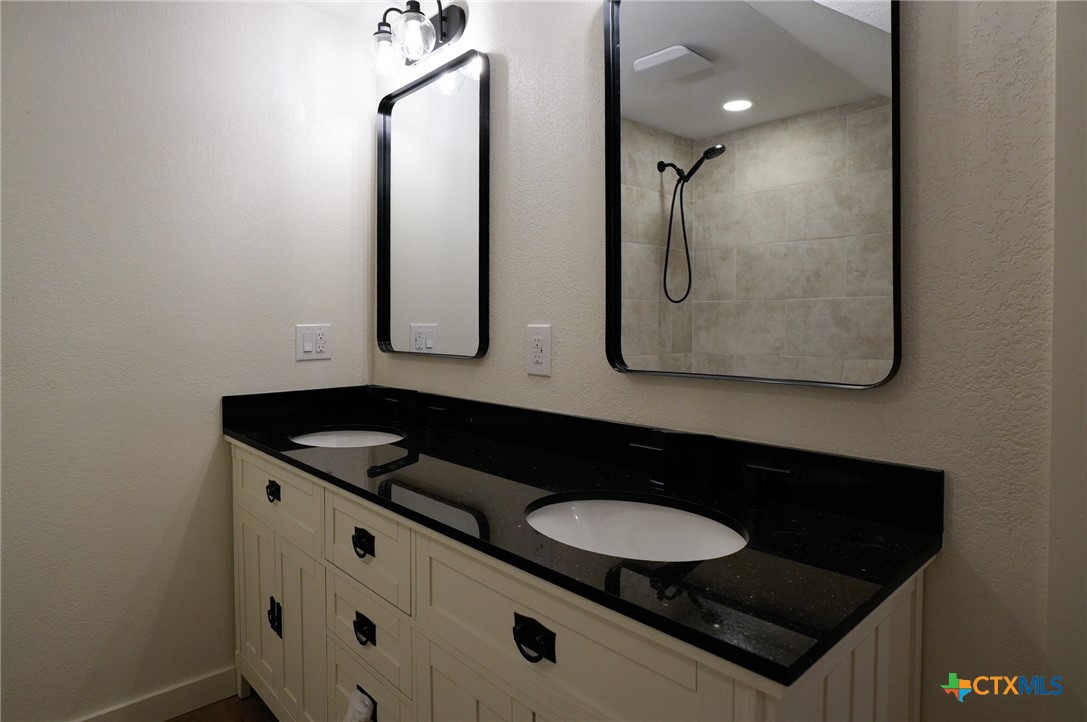 5688 Falke-Heinrich Road Schulenburg, TX 78956 - Photo 31 of 34 a bathroom with a granite countertop sink and a mirror