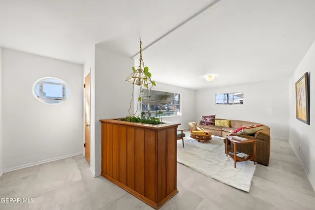 a living room with furniture a dining table and a window