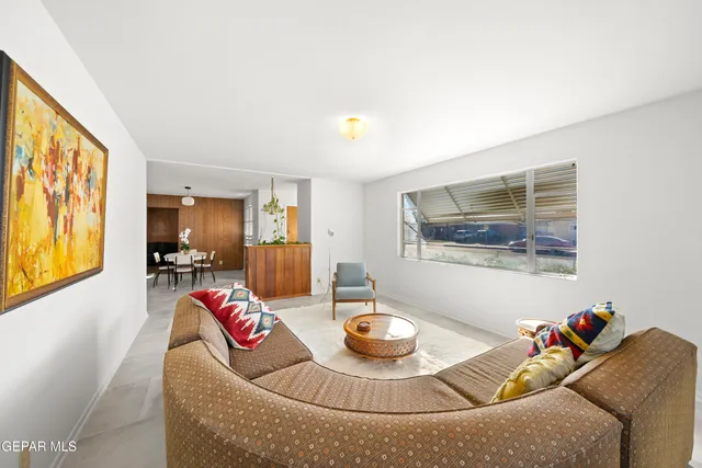 a living room with furniture and painting on the wall