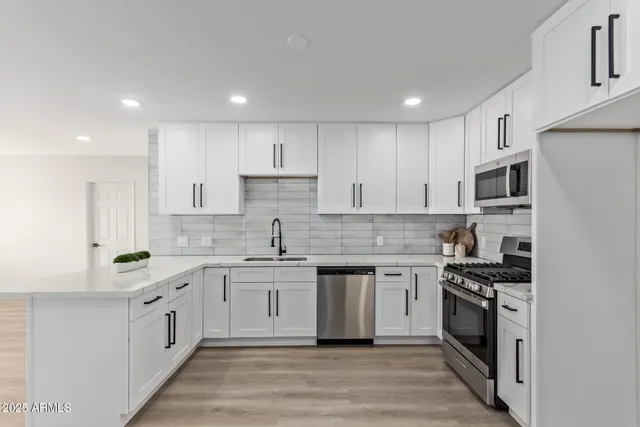 a kitchen with stainless steel appliances granite countertop a stove top oven a sink and cabinets