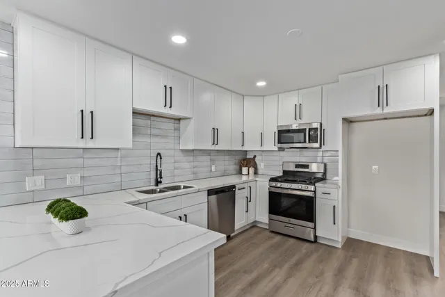 a kitchen with a sink a stove a refrigerator and cabinets