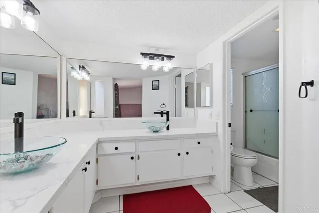 a spacious bathroom with a granite countertop sink and a mirror