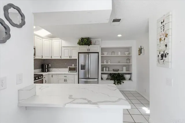 a kitchen with stainless steel appliances kitchen island granite countertop a refrigerator and a stove top oven