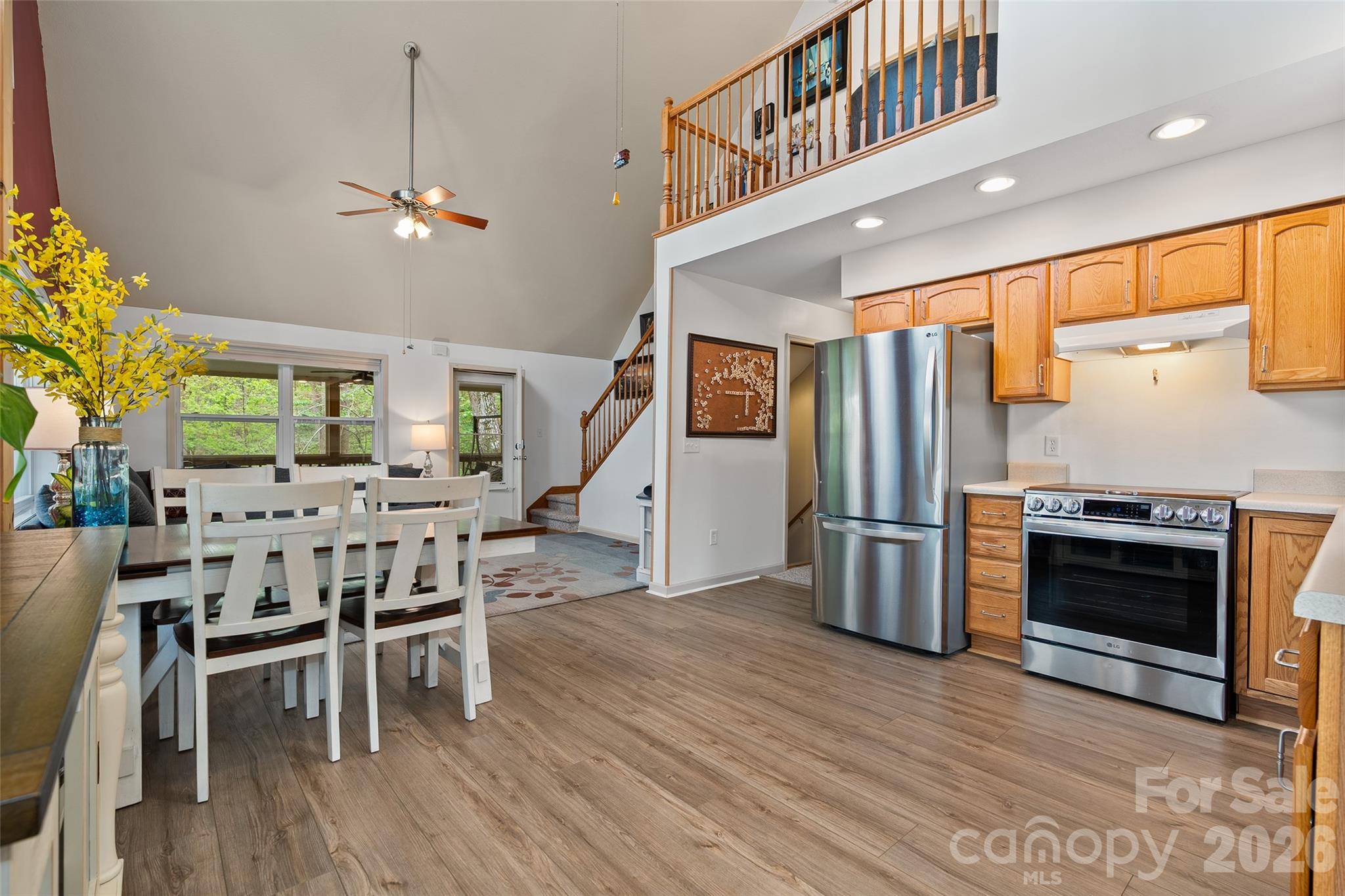 215 Atkins Loop Lake Junaluska, NC 28745 - Photo 6 of 44 a kitchen with stainless steel appliances kitchen island granite countertop a refrigerator a stove a microwave oven a dining table and chairs with wooden floor