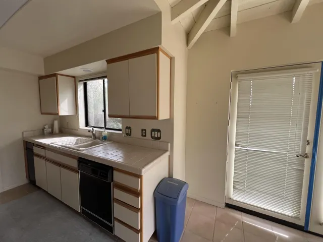 a view of an empty room with wooden floor and windows