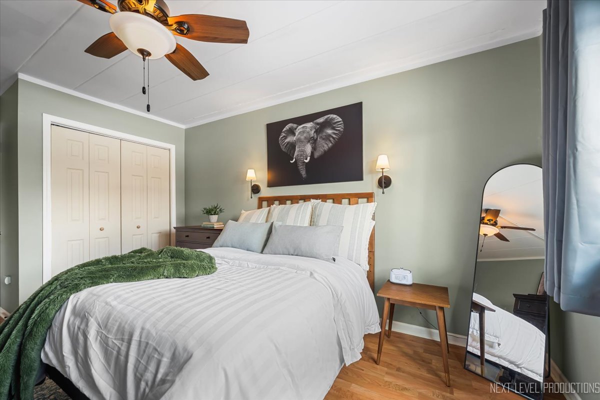 127 North Wolf Road, Unit 60A Wheeling, IL 60090 - Photo 10 of 22 a bedroom with a bed and a chandelier