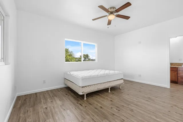 a room with a wooden floor and a ceiling fan