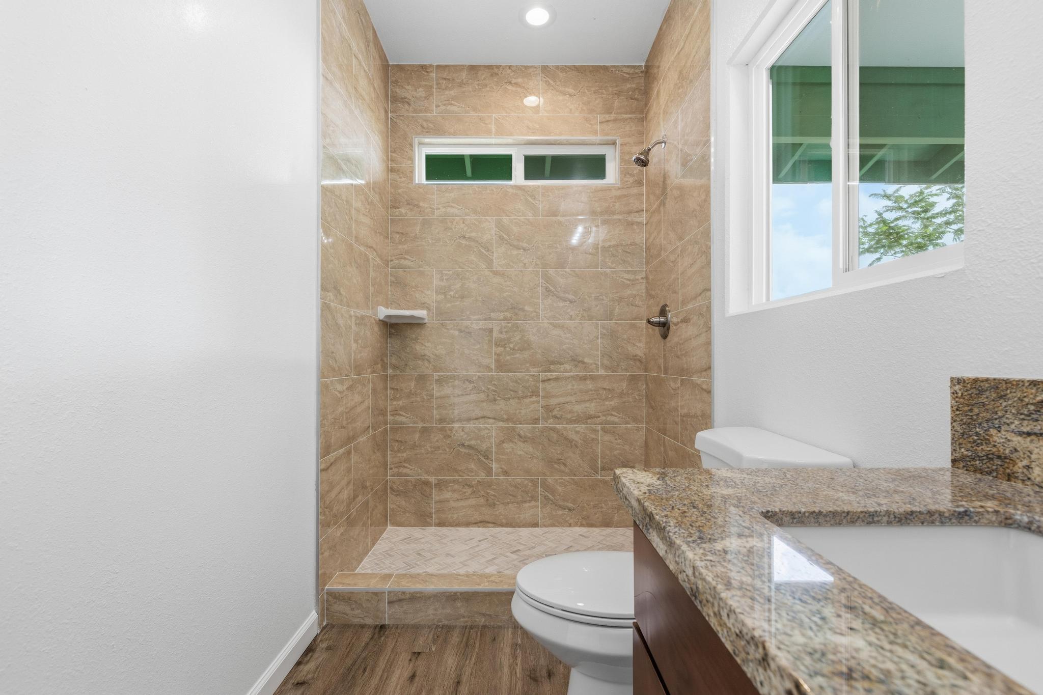 18-7842 Kaniela Road Mountain View, HI 96771 - Photo 17 of 30 a bathroom with a granite countertop bathtub toilet and sink
