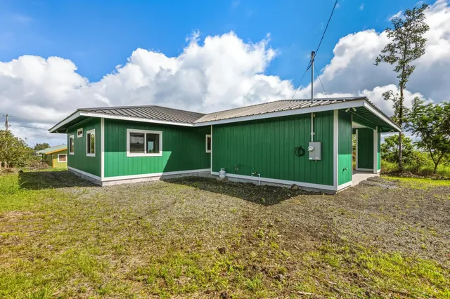 a view of a house with a yard and potted plants