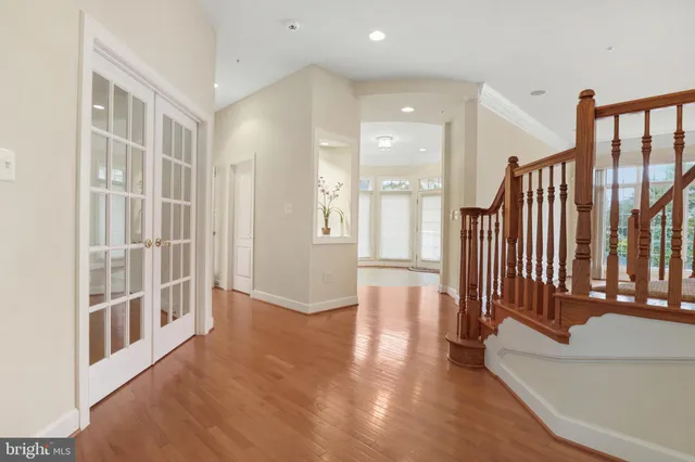 an empty room with chandelier fan and windows