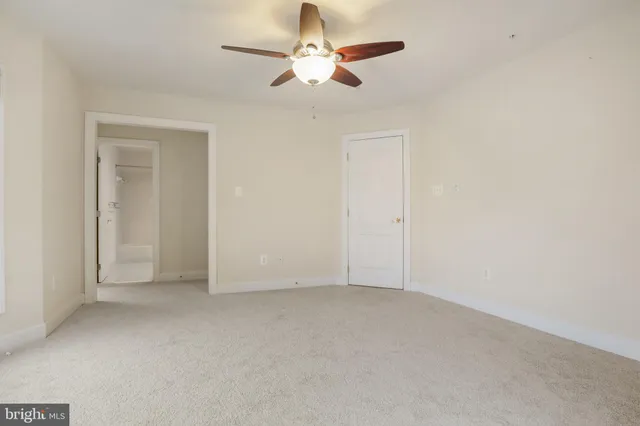 a view of an empty room with a fireplace and a window