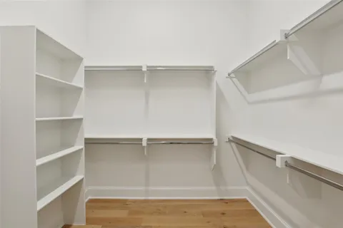 a view of walk in closet with empty racks