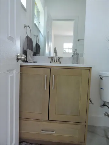 a bathroom with a sink a mirror and a window