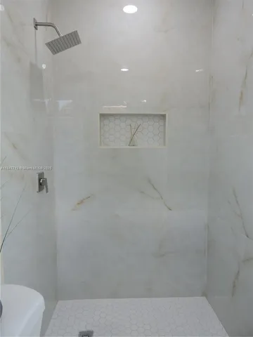 a white toilet sitting next to a shower