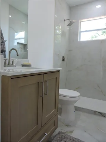 a bathroom with a window a toilet and a shower